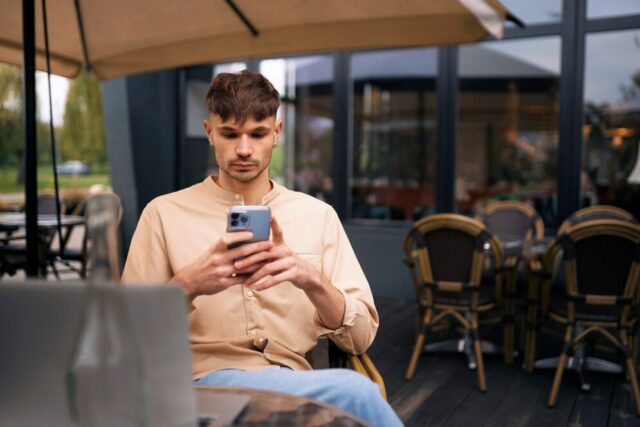 front-view-man-holding-smartphone_23-2149930148